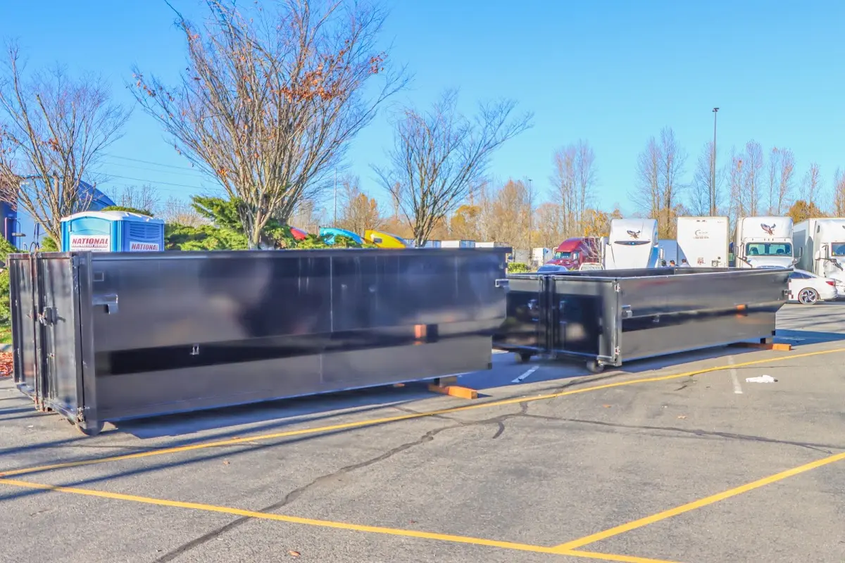 Professional dumpster rental service with roll-off container on residential driveway in Hoschton